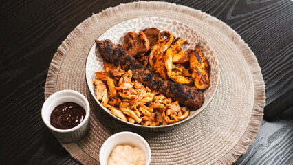 A beautifully arranged platter of grilled chicken shish, lamb shish, and doner kebab, served with vibrant sauces on the side. Elegant plating for food photography, menus, and promoting healthy, protei