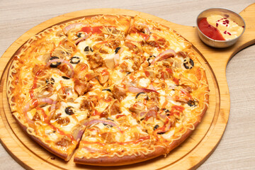 Hot Pizza Topped with Chicken, Onion, Olives, and Cheese on cutting board side view of bangladeshi food