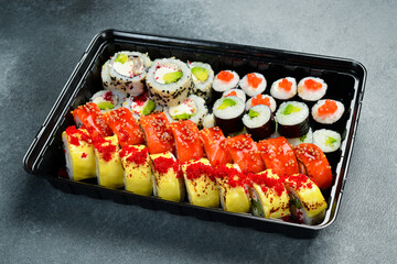 Set of sushi rolls and maki with fish, caviar, cheese and avocado. Close-up.