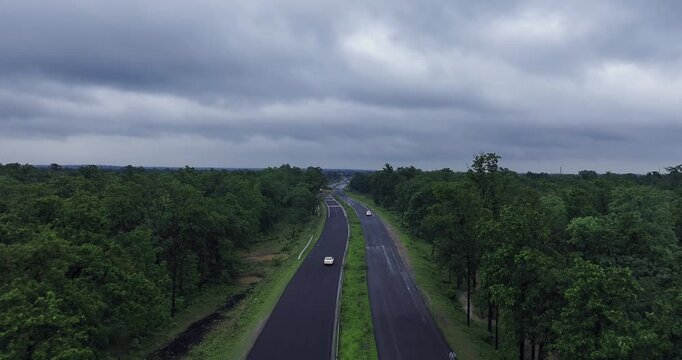 Bhopal, Madhya Pradesh, India, 20 July 2025: Aerial view of the Bhopal-Nagpur Highway captured during the monsoon season. The modern roadway stretches through lush green fields and mist-covered hills.
