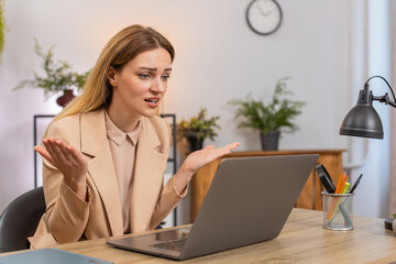Middle-aged businesswoman at home office sees sales drop on laptop graph red arrow down frowns...