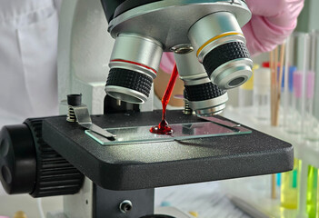 Microscope being used to analyze blood sample in laboratory