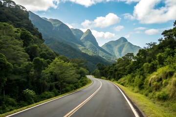 A winding road cuts through a lush, green mountain landscape under a partly cloudy sky, inviting exploration and adventure amidst the natural beauty and serene atmosphere of the countryside