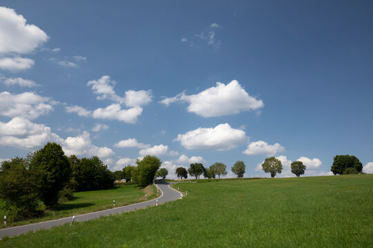 road in the countryside with clouds and blue sky