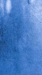 Close-up of a blue painted wall with visible grunge stains and subtle scratches