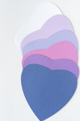 staggered  pile of large paper hearts on blank paper