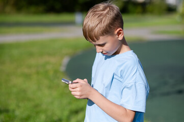 Teen boy looking at smartphone in park
