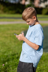 Teen boy looking at smartphone in park