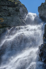 The waterfall plays with splashes in the sun