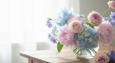 Soft bouquet of pastel pink and blue flowers, likely hydrangeas and roses, against a bright white background.