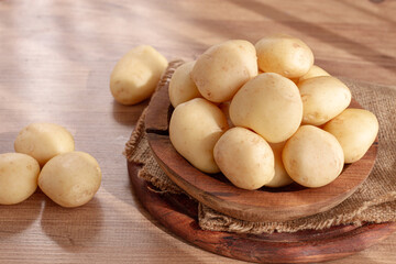 boiled new potatoes, in a wooden bowl, on a rustic table, natural light, no people,
