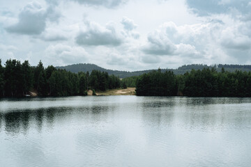 The lake at the disused Krzeszówek mine in Krzeszówek, on a summer afternoon with an overcast sky. Poland, Lower Silesia.