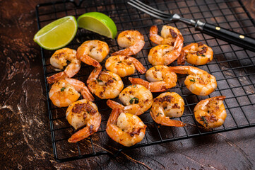 Grilled Shrimps Prawns with garlic on a rack. Brown background. Top view