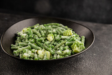 Frozen green vegetables green peas, broccoli, string beans, kohlrabi kale tasty snack fresh food background on the table rustic food top view copy space keto and paleo diet vegan and vegetarian food