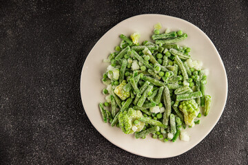 Frozen green vegetables green peas, broccoli, string beans, kohlrabi kale tasty snack fresh food background on the table rustic food top view copy space keto and paleo diet vegan and vegetarian food
