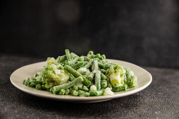 Frozen green vegetables green peas, broccoli, string beans, kohlrabi kale tasty snack fresh food background on the table rustic food top view copy space keto and paleo diet vegan and vegetarian food