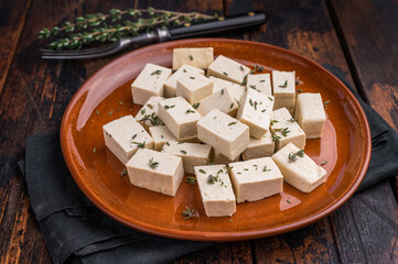 Uncooked Diced soybean tofu cheese on plate. wooden background. top view