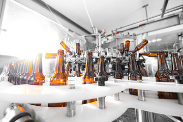 Automated beer bottling line in modern brewery facility with machines and glass bottles