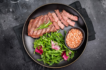 Grilled Top blade steak with salad, beef shoulder meat on a plate. black background. top view