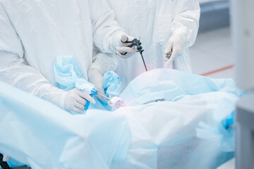 Surgeons performing laparoscopic surgery in operating room with precision instruments