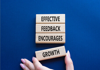 Feedback symbol. Wooden blocks with words Effective Feedback encourages growth. Businessman hand....