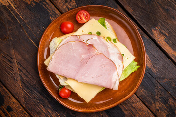 Prosciutto Cotto Ham and cheese sandwich, toast with sliced meat, cheese and salad. wooden background. top view