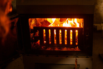 solid fuel heater stove, with wood stacked in it, keeping the fire going for warmth