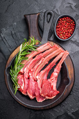 Ready for cooking Raw lamb meat chops, fresh mutton cutlets in a pan. black background. top view