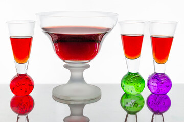 Red-brown alcoholic punch served in clear glass glasses on a white background, showcasing the elegance of drinkware, reflections, and the rich color of the beverage in a studio setting.