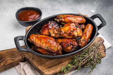 Grilled chicken wings smothered in sweet and sour sauce, poultry meat. white background. top view