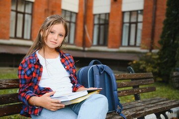 Beautiful schoolgirl with a backpack and books. Back to school