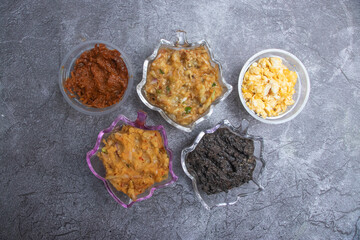 Assorted bengali bhorta of Tok, Kalo Jira, Mashed Egg, Begun Bhorta and Mashed Lentils in bowls top view of South Asian cuisine