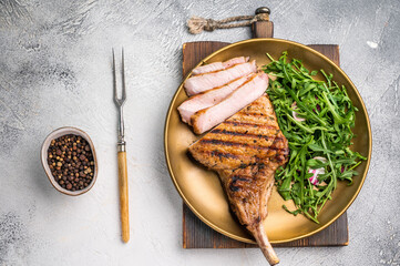 Mouthwatering grilled pork chop with a stunning presentation, perfect for serving at special occasions. grey background. top view