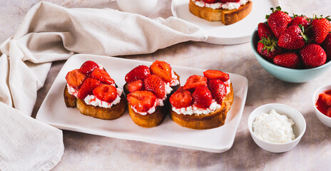 Appetizing bruschetta with ricotta and stewed strawberries on a plate web banner