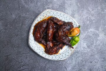 Glazed BBQ Chicken Wings with Hot Peppers on a Plate top view of restaurant food