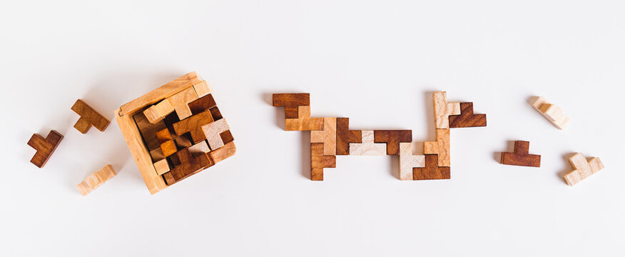 Wooden puzzle figures are folded into a box and between each other top view and web banner