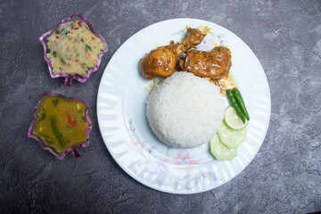 Bangladeshi Chicken Curry with Rice, aloo bhorta, dal and salad in plate top view of South Asian food