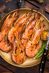 Grilled red Argentine shrimps, Prawns Langostino Austral on a plate with herbs. wooden background. top view