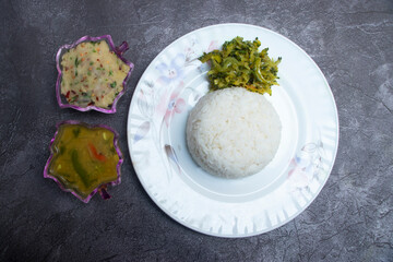 Vegetarian set menu with rice, aloo bhorta, dal curry and fried bitter gourd in plate top view of Bangladeshi food