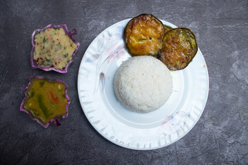 Traditional thali with rice, dal, aloo bhorta and begun bhaja in plate top view of Bangladeshi Set Meal