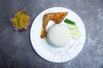 Fried chicken leg with rice and lentil curry on a white plate top view of Bengali food