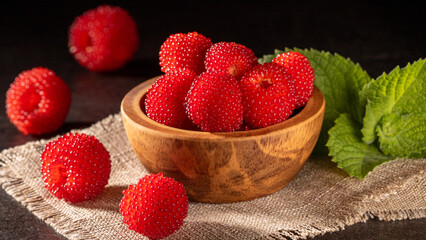 Close-up of bright tibetan raspberries in a wooden bowl, fresh and vibrant