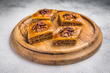 Arabic Traditional Honey Walnut Baklava on wooden board. grey background. top view