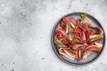 Meat appetizer dried duck breast fillet meat slices, magret smoked poultry. grey background. top...
