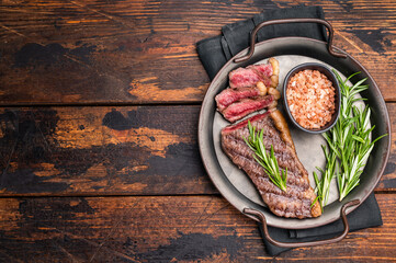 BBQ grilled Top Sirloin beef steak with herbs. wooden background. top view