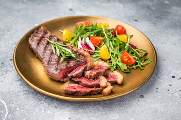 Grill Top Sirloin beef steak, rump steak with salad on a plate. grey background. top view