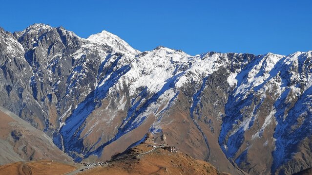 Vista a la iglesia de Gergeti Trinity con las monta&ntilde;as del caucaso de fondo - Kazbegi en Georgia