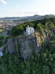 Obraz premium Aerial drone footage of the Pastyrska Stena lookout tower in Decin, Czech Republic. Scenic panoramic views of the historic tower, sandstone cliffs, and the Elbe River surrounded by nature 