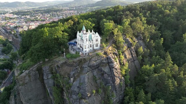 Aerial drone footage of the Pastyrska Stena lookout tower in Decin, Czech Republic. Scenic panoramic views of the historic tower, sandstone cliffs, and the Elbe River surrounded by nature 