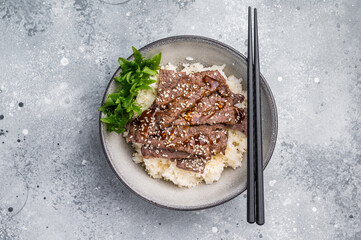 Delectable yakiniku feast, featuring a variety of marbled beef cuts and rice. A culinary journey that captures the essence of Japanese grilling traditions. grey background. top view